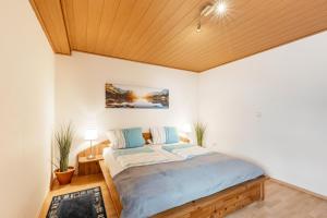 a bedroom with a bed with a wooden ceiling at Ferienwohnung mit Aussicht in Notscheid