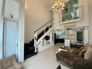 a living room with a couch and a staircase at Duplex 775sq ft near Mid Valley in Kuala Lumpur