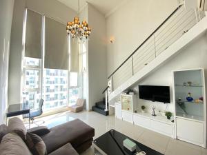 a living room with a couch and a staircase at Duplex 775sq ft near Mid Valley in Kuala Lumpur