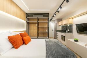 a bedroom with a large white bed with orange pillows at GO24 by LikeHome in Auxiliadora