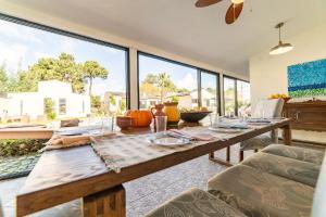 d'une salle à manger avec une table et de grandes fenêtres. dans l'établissement Villa Praia e Floresta, à Aroeira