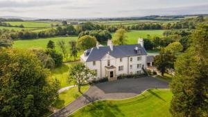 an aerial view of a large white house with a driveway at Underwood House Garden Flat in Kilmarnock