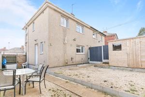 a patio with a table and chairs in front of a building at Cozy 3 Bedroom House For Short and Long Stay in Lower Gornal