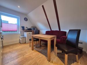 a dining room with a table and two chairs at Ferienwohnung Leer-Stadtmitte, 15131 in Leer +5 photos