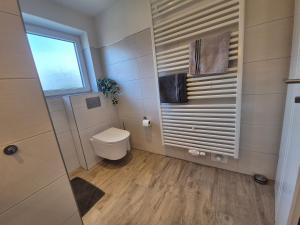a small bathroom with a toilet and a window at Ferienwohnung Leer-Stadtmitte, 15131 in Leer
