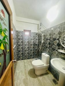 a bathroom with a toilet and a sink at ABC Guest Inn & Restaurant in Haputale
