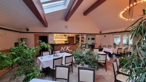 a dining room with tables and chairs and plants at Haus Katharinensee in Müllrose