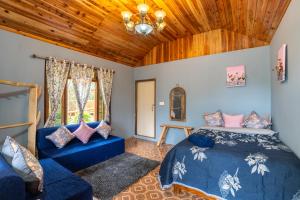 a bedroom with a blue bed and a blue couch at Monratino The Orange Farmstay - Darjeeling in Takdāh