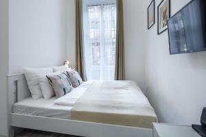 Un dormitorio con una cama con sábanas y almohadas blancas. en New Studio Top Location, en Budapest