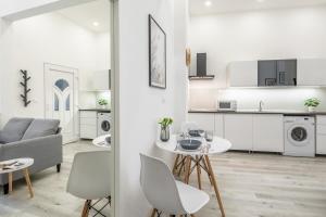 cocina blanca y sala de estar con mesa y sillas. en New Studio Top Location, en Budapest 11 fotos más