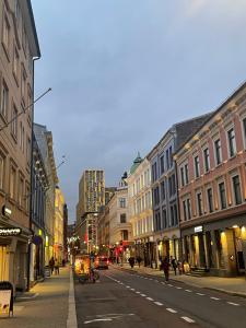 a city street with buildings and people walking down the street at OSLO S, City Center Apartments in Oslo