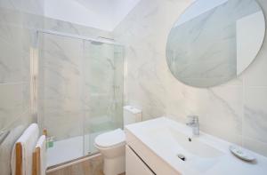 a bathroom with a toilet and a sink and a mirror at Ocean & Sun Terrace w AC, by TimeCooler in Costa da Caparica
