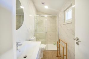 a bathroom with a shower and a sink and a toilet at Ocean & Sun Terrace w AC, by TimeCooler in Costa da Caparica
