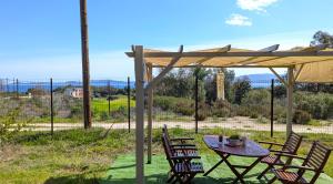 a table and chairs under a wooden umbrella at Vanna's Holiday House in Ierissos