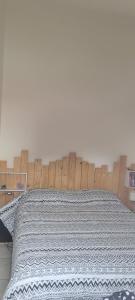 拉贝尔讷里昂雷茨Appartement vue mer的卧室里有一张带木质床头板的床