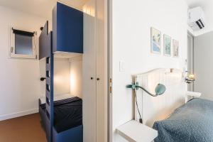 um pequeno quarto com uma cama e um candeeiro em La Dune, appart familial vue mer em Rivedoux-Plage