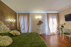 a living room with a green couch and a table with a television at Casa Savoia & Casa Jolanda in Venice