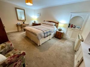 a bedroom with a bed and a table and a mirror at Beach Cottage in a Tranquil Location in Kingsbarns