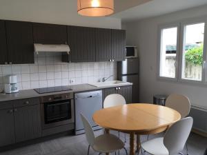 a kitchen with a wooden table and a table and chairs at Charmante maison au cœur du village in Saint-Nicolas-de-Bourgueil