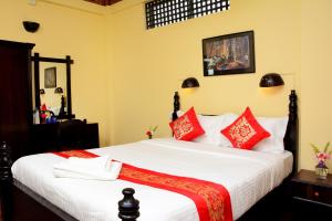 カトマンズにあるドリーム ネパール ホテル アンド アパートのベッドルーム1室(大型ベッド1台、赤い枕付)