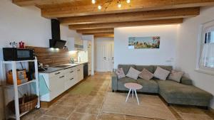 a living room with a couch and a kitchen at Zimmer mit Aussichthochzehn in Himmelberg