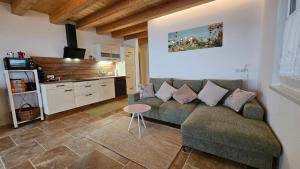 a living room with a couch and a kitchen at Zimmer mit Aussichthochzehn in Himmelberg