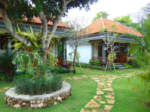 a house with a garden in front of it at Griyani Homestay in Uluwatu +22 photos
