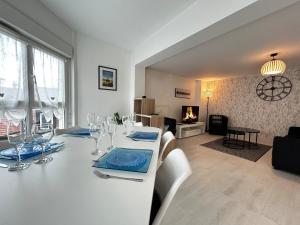 una sala da pranzo con tavolo bianco, sedie e camino di E Mercier magnifique grand T2 à deux pas du centre a Épernay