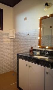 un bagno con lavandino e specchio di Chácara Amsterdam ad Aracaju