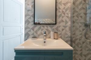 a bathroom with a sink and a mirror at Maison Cosy - Coeur de Village - Cour Privative in Bagnères-de-Bigorre