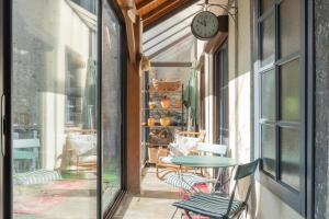 a balcony with a table and chairs and a clock at Maison Cosy - Coeur de Village - Cour Privative in Bagnères-de-Bigorre