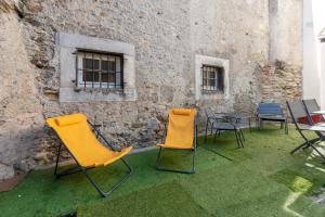 a group of chairs and tables in front of a building at Maison Cosy - Coeur de Village - Cour Privative in Bagnères-de-Bigorre