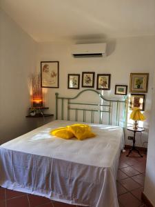 a bedroom with a bed with a yellow blanket on it at Cottage with a great fenced garden in the Tuscan countryside in Cecina