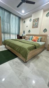 1 dormitorio con 1 cama grande y edredón verde en Bumble bee Jaipur, en Jaipur