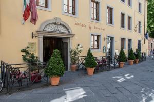 ein Gebäude mit Stühlen und Pflanzen davor in der Unterkunft San Luca Palace in Lucca