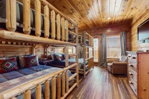 a log cabin living room with a couch and bunk beds at Laurel Wood Cove in Gatlinburg