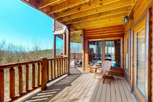 ガトリンバーグにあるLaurel Wood Coveの椅子付きの小屋の木製のポーチ