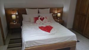 a large white bed with two hearts on it at MC Self Catering in Baie Sainte Anne