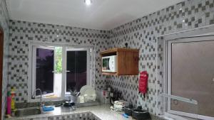 a kitchen with a sink and a window at MC Self Catering in Baie Sainte Anne