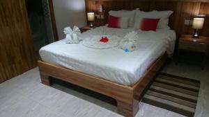 a bedroom with a large white bed with decorations on it at MC Self Catering in Baie Sainte Anne