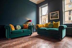 巴斯Exquisite grandeur - Central Bath的客厅设有两张绿色沙发和一个窗户