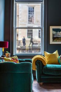 巴斯Exquisite grandeur - Central Bath的客厅设有绿色沙发和窗户。