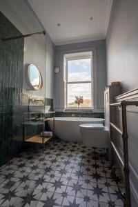 巴斯Exquisite grandeur - Central Bath的带浴缸、马桶和窗户的浴室
