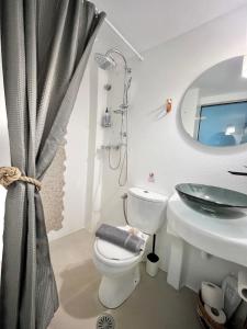 Un baño con inodoro, lavabo y espejo. en Sea & City Naxos, en Naxos Chora