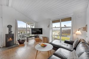 a living room with a couch and a fireplace at Charming Holiday Home Close To The North Sea And Søndervig Center in Ringkøbing