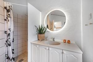 a white bathroom with a sink and a mirror at Charming Holiday Home Close To The North Sea And Søndervig Center in Ringkøbing +19 photos