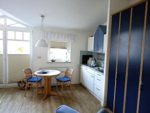 eine Küche mit Tisch und Stühlen in einem Zimmer in der Unterkunft Fewo Rosenhof 16 in Kühlungsborn