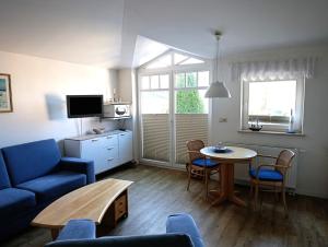 ein Wohnzimmer mit einem blauen Sofa und einem Tisch in der Unterkunft Fewo Rosenhof 16 in Kühlungsborn