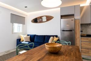 a living room with a table and a blue couch at Sunset House - by Monte das Alpenduradas in Zambujeira do Mar +4 photos