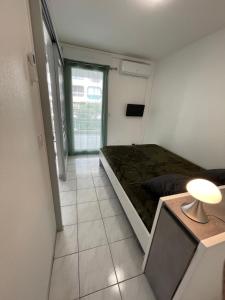 a small room with a bed and a lamp in it at Frejus Plage in Fréjus